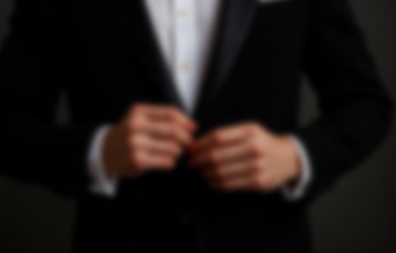 A man adjusting a rental tuxedo lapel, highlighting the quality of our rental selection